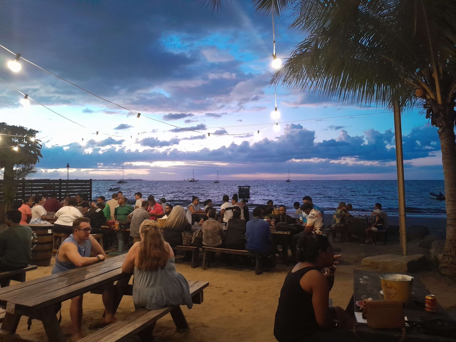 Sunset beach bar in Fiji with fairy lights and palm trees